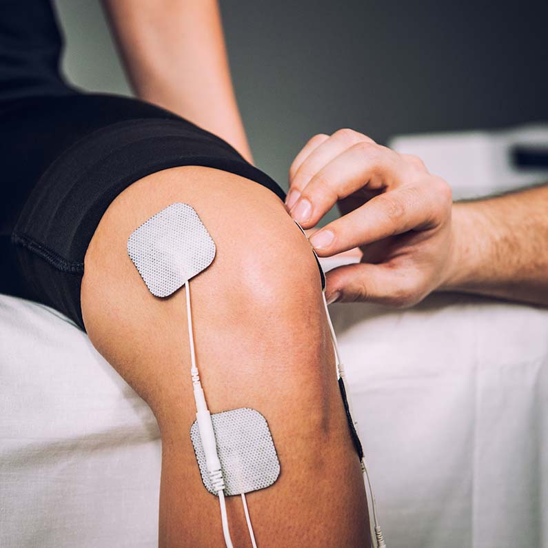 TENS electrodes positioned to treat knee pain in physical therapy